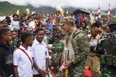 The Indonesian Military's (TNI) Joint Regional Defense Command (Kogabwilhan) III commanding general Lt. Gen. Bambang Trisnohadi (right) talks to two Papuan students on Feb. 17 during a public kitchen event in Tinibil village in Oksamol district, Pegunungan Bintang regency, Papua Highlands, in this picture provided by the Defense Ministry. Kogabwilhan III also provided basic medical service for villagers.