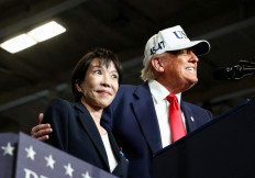 Japanese Prime Minister Sanae Takaichi reacts as U.S. President Donald Trump speaks, aboard the aircraft carrier USS George Washington, during a visit to US Navy's Yokosuka base in Yokosuka, Japan, on Oct. 28, 2025.
