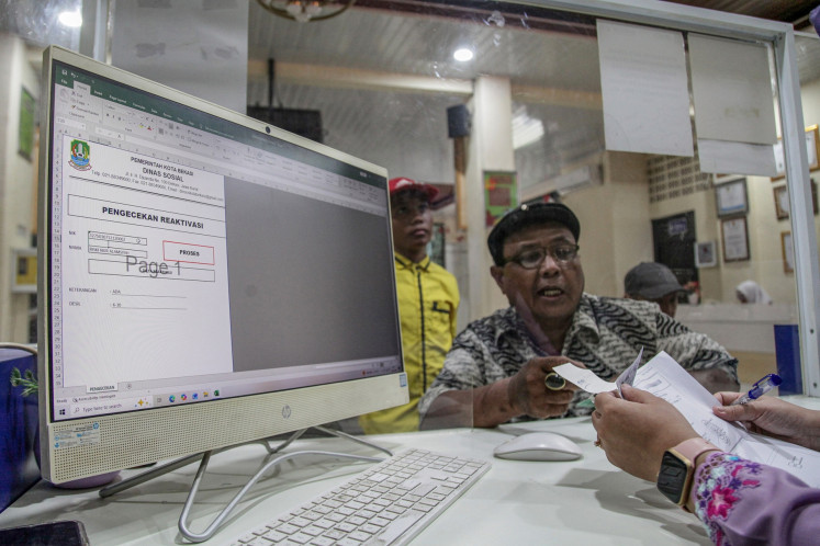 A patient files a request on Feb. 13, 2026, to reactivate his subsidized national health insurance (JKN) policy at the Bekasi Municipality Social Affairs Agency in Bekasi, West Java.