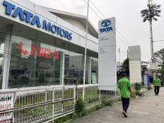 A man walks past a Tata Motors dealership on Wednesday in the Kramat area of Central Jakarta. Indonesia has decided to import 105,000 cars from India through the Red and White Rural Cooperatives (KDMP) program.