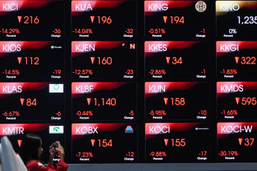 A woman takes a photo of an electronic display showing negative movements across the Indonesia Stock Exchange (IDX) Composite index on Feb. 2, 2026, at the bourse&rsquo;s South Jakarta headquarters. 