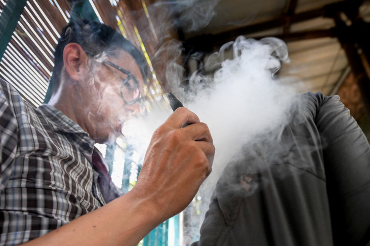 A man uses a vape, or e-cigarette, on June 10, 2024, in Jakarta.