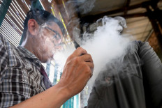A man uses a vape, or e-cigarette, on June 10, 2024, in Jakarta.