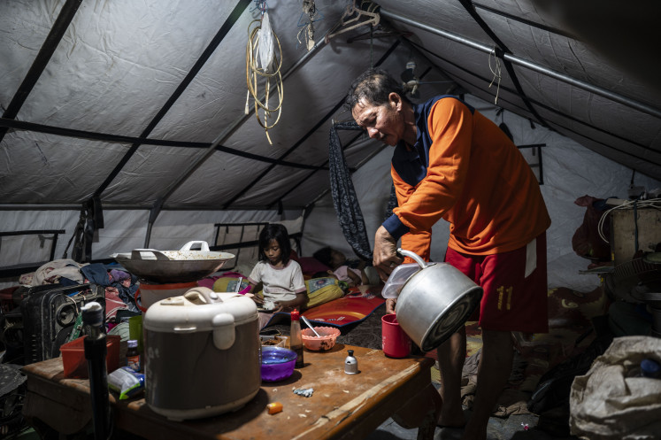 Ramadan under tents: Disaster survivors have a predawn meal (sahur) on Feb. 19, 2026, at an emergency shelter in Bundar village, Karang Baru, Aceh Tamiang, Aceh. About 23 families liveed at the site, and cook simple meals for their sahur as they observe the Ramadan fast.