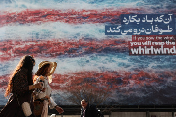 Iranian women walk past an anti-United States billboard in Tehran, Iran, on Feb. 19, 2026.