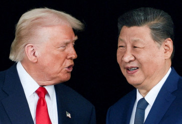 United States President Donald Trump and Chinese President Xi Jinping talk as they leave after a bilateral meeting on the sidelines of the Asia-Pacific Economic Cooperation (APEC) summit in Busan, South Korea, on Oct. 30, 2025.