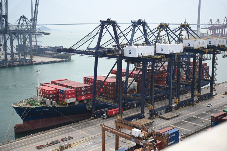 A container ship unloads its cargo at Kwai Chung Container terminal in Hong Kong on April 10, 2025. US President Donald Trump abruptly paused tariffs on most countries, sparking euphoria on global markets on April 10, but upped the ante on a brutal trade war with superpower rival China.