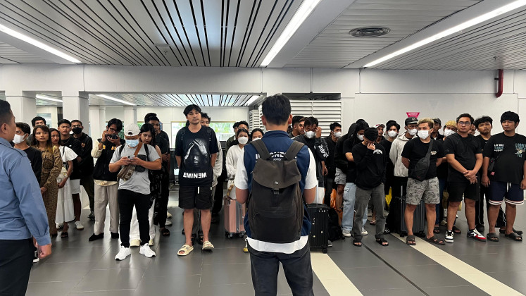 Indonesian nationals line up on Sunday during questioning at Soekarno-Hatta International Airport in Tangerang, Banten, upon returning from Cambodia on commercial airlines. The largest group of returning citizens entangled in online scam operations in Cambodia underwent questioning to distinguish trafficking victims from those who knowingly participated in criminal activities.