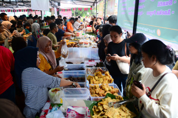 People crowd around vendors selling snacks for iftar on Feb. 22, 2026, at the Bendungan Hilir Ramadan Takjil Bazaar in Tanah Abang, Central Jakarta.