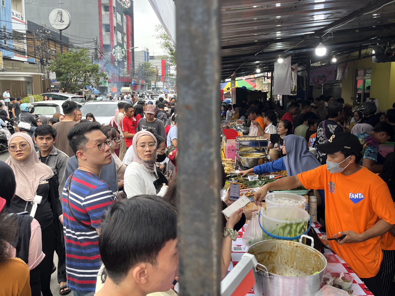Residents crowd to choose snacks on Feb. 22, 2026, at the Pasar Takjil Ramadan Bendungan Hilir in Central Jakarta. The Benhil Ramadan market draws large numbers of visitors during the holy month of Ramadan, seeking a variety of iftar dishes, including fried snacks sold for Rp 4,000 (24 US cents) each, 'bubur sumsum' (rice porridge) priced at Rp 15,000 to Rp 20,000 per serving, fried chicken at Rp 15,000 to Rp 20,000 per piece and other foods for breaking the fast. The market opens at 2 p.m.