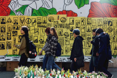 Women walk along a main street in Tehran on Feb. 21, 2026. The United States and Iran are facing off with threats of military action, even as the arch-foes pursue fresh negotiations.