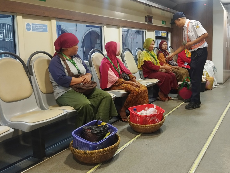 Special courtesy: Train attendant J.S. Suparmin (right) asks passengers to show their passenger cards in the Farmer and Trader Car of a Rangkasbitung-Merak train on Feb. 17, 2026, after they boarded at Rangkasbitung Station in Lebak regency, Banten.