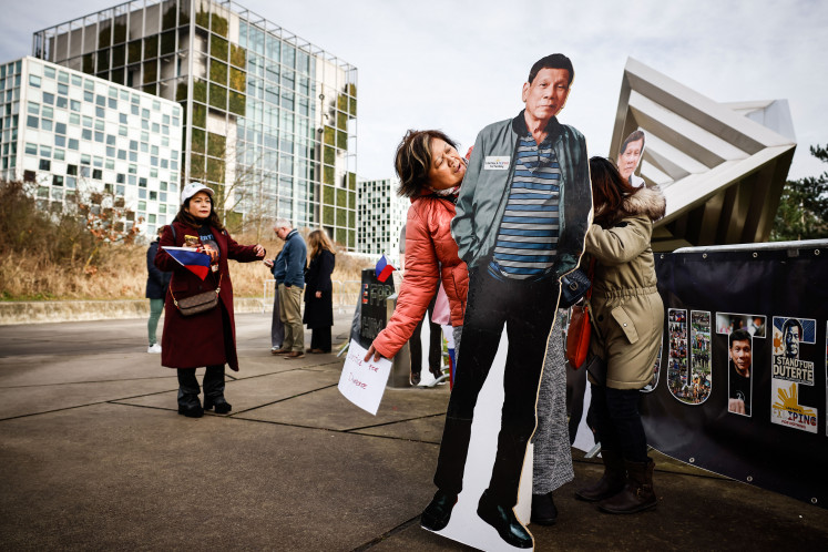 A protester holds a life-size cardboard cutout of former Philippines president Rodrigo Duterte during a demonstration on Feb. 23 in support of him outside the International Criminal Court (ICC) in The Hague, the Netherlands, where he is on trial on charges of crimes against humanity.