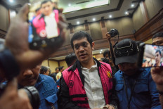 Muhammad Kerry Adrianto Riza (center), owner of fuel terminal company PT Orbit Terminal Merak and son of oil tycoon Riza Chalid, is escorted out of the courtroom on Feb. 27 at the Jakarta Corruption Court in Jakarta. Judges sentenced Kerry to 15 years in prison after finding him guilty in a corruption case pertaining to the lease of an oil terminal to state energy firm Pertamina. 