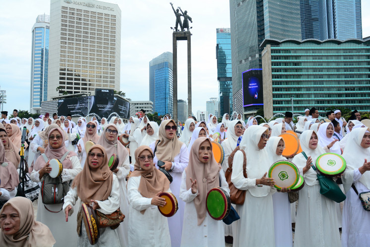 A rebana music group plays percussion instruments while chanting salawat (praise for Prophet Muhammad) during the Rebana Ramadan Colossal event on Feb. 27  at the Hotel Indonesia traffic circle in Central Jakarta.