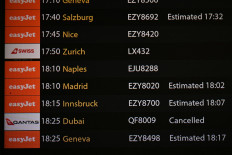 The arrivals board is seen, showing a cancelled flight from Dubai, in the north terminal at London Gatwick airport in Crawley, on February 28, 2026, following the US and Israel's strikes on Iran. 
