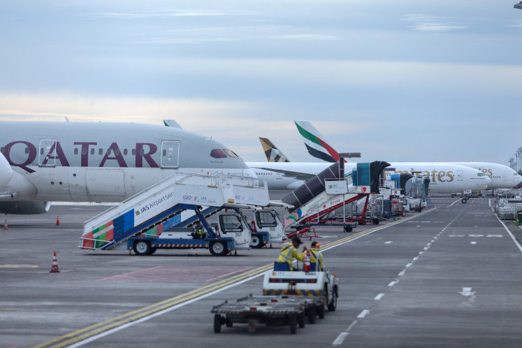 Qatar Airways and Emirates Airways planes are parked at I Gusti Ngurah Rai International Airport as some flights to Dubai and Doha were canceled on March 1, following strikes on Iran launched by the United States and Israel, in Kuta, Bali.