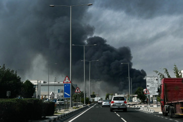 Motorists drive past a plume of smoke rising from a reported Iranian strike in the industrial district of Doha on March 1, 2026. US President Donald Trump said on February 28 that Iran's supreme leader Ayatollah Ali Khamenei was dead, after Israel and the United States launched an attack of unprecedented scale aimed at bringing down the Islamic republic. 