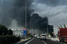 Motorists drive past a plume of smoke rising from a reported Iranian strike in the industrial district of Doha on March 1, 2026. US President Donald Trump said on February 28 that Iran's supreme leader Ayatollah Ali Khamenei was dead, after Israel and the United States launched an attack of unprecedented scale aimed at bringing down the Islamic republic. 
