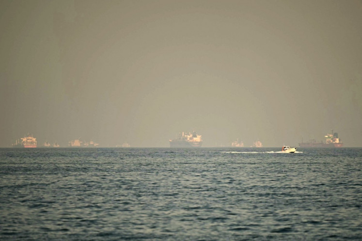 Cargo ships and tankers are seen off coast city of Fujairah, in the Strait of Hormuz in the northern Emirate on February 25, 2026. 