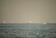 Cargo ships and tankers are seen off coast city of Fujairah, in the Strait of Hormuz in the northern Emirate on February 25, 2026. 