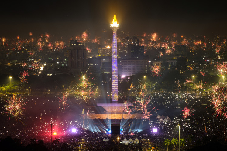 Fireworks explode over Jakarta on Jan. 1, 2024, to usher in the New Year, as revelers gather around the illuminated National Monument (Monas) in Jakarta.