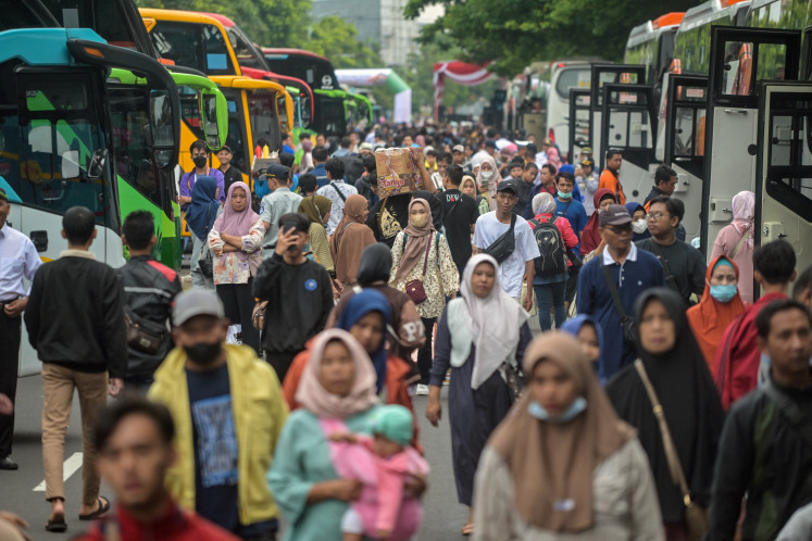 People arrive to catch free buses provided by the government to their home towns on March 29, 2025, ahead of last year's Idul Fitri, marking the end of the Islamic fasting month of Ramadan in Surabaya, East Java.