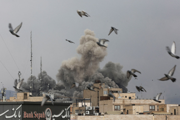 Birds fly as smoke rises following an explosion, after Israel and the United States launched strikes on Iran, in Tehran on March 3, 2026.
