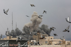 Birds fly as smoke rises following an explosion, after Israel and the United States launched strikes on Iran, in Tehran on March 3, 2026.
