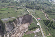 A large land subsidence reaches the road on Feb. 6 in Pondok Balik village in Ketol district, Central Aceh regency, Aceh. Although colloquially called a sinkhole, technically the collapsing land is not a sinkhole due to different soil structure.