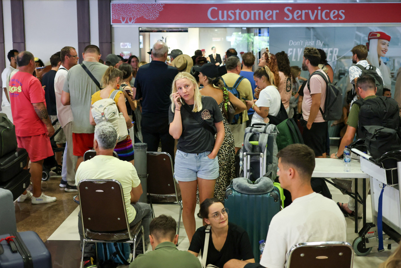 Stranded: Would-be passengers wait near the Emirates customer service office on March 1, 2026, at I Gusti Ngurah Rai International Airport in Kuta, Bali, after flights to Middle East cities were canceled following strikes on Iran launched by the United States and Israel.