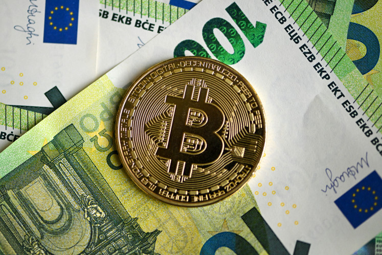 A commemorative Bitcoin coin is pictured on 100 euros notes in Dortmund, Germany, on Feb. 9, 2026.