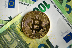 A commemorative Bitcoin coin is pictured on 100 euros notes in Dortmund, Germany, on Feb. 9, 2026.
