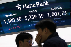 Currency dealers talk in front of an electronic board displaying the Korea Composite Stock Price Index (KOSPI), the exchange rate between the US dollar and South Korean Won and the Korea Securities Dealers Automated Quotations (KOSDAQ) at the dealing room of a bank in Seoul on March 4, 2026. 