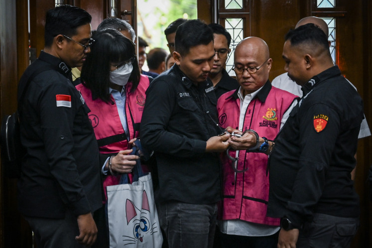 Marcella Santoso (second left) and Ariyanto Bakri (second right), defendants in a bribery case linked to the acquittal of companies in a crude palm oil (CPO) export corruption case, enter the Jakarta Corruption Court on March 3, 2026. 
