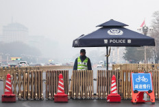 A police officer stands guard at a checkpoint at Changan Avenue on a foggy day ahead of the annual meeting of the National People's Congress in Beijing on March 2, 2026.