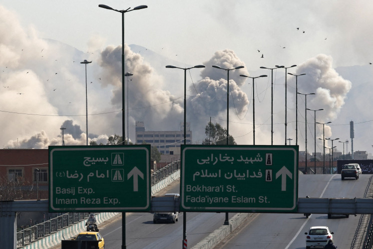 Vehicles drive along an expressway against the backdrop of smoke rising after a strike on the Iranian capital of Tehran on March 5, 2026. Israel pounded Tehran with fresh strikes and Iran targeted Kurdish guerilla groups in Iraq on March 5 as a spiralling war in the Middle East engulfed the entire region. 
