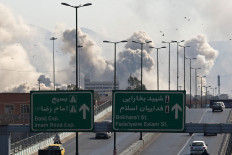 Vehicles drive along an expressway against the backdrop of smoke rising after a strike on the Iranian capital of Tehran on March 5, 2026. Israel pounded Tehran with fresh strikes and Iran targeted Kurdish guerilla groups in Iraq on March 5 as a spiralling war in the Middle East engulfed the entire region. 