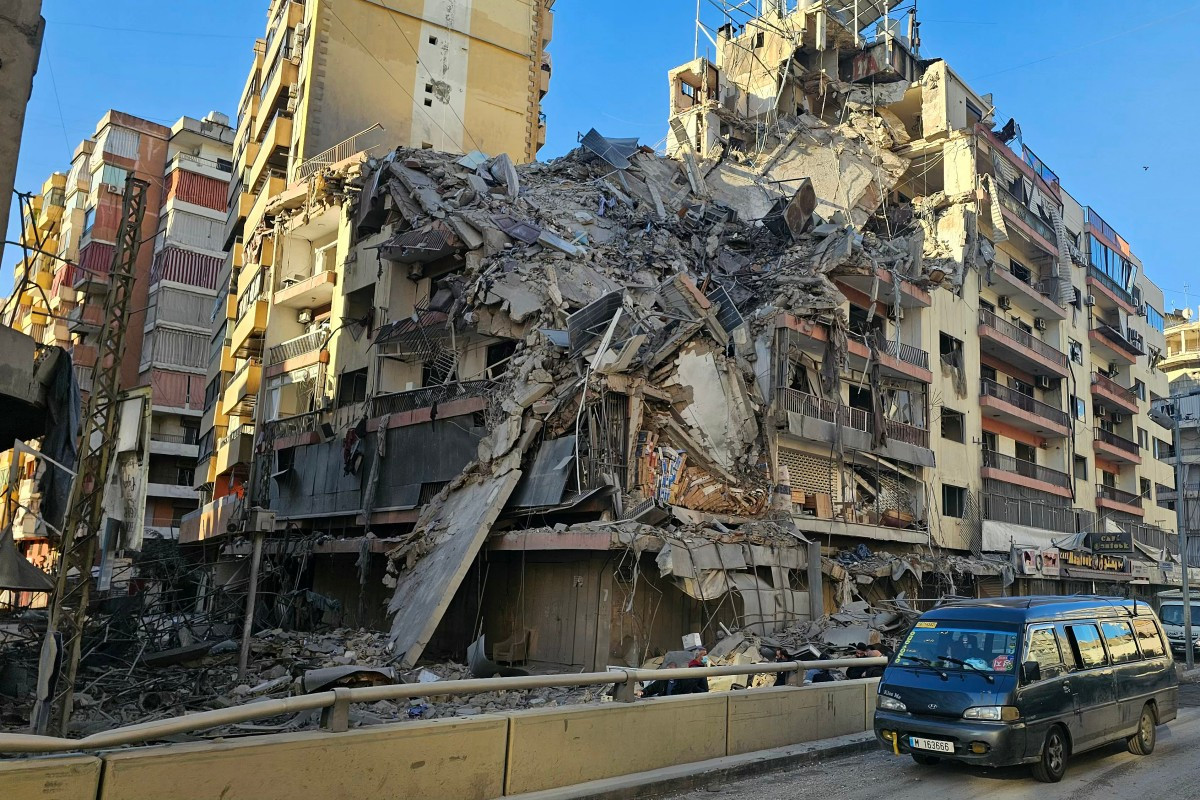 A van drives past a destroyed building following airstrikes in Beirut's southern suburbs of Ghobeiry neighborhood, on March 5, 2026. 