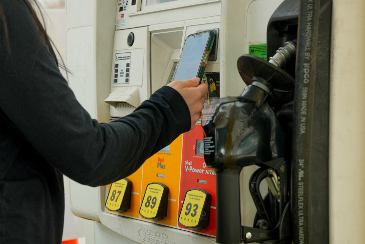 A woman pays for gas at a Shell station as the price of oil and gas has surged amid the US-Israeli conflict with Iran, in Washington, DC, on March 5, 2026. 