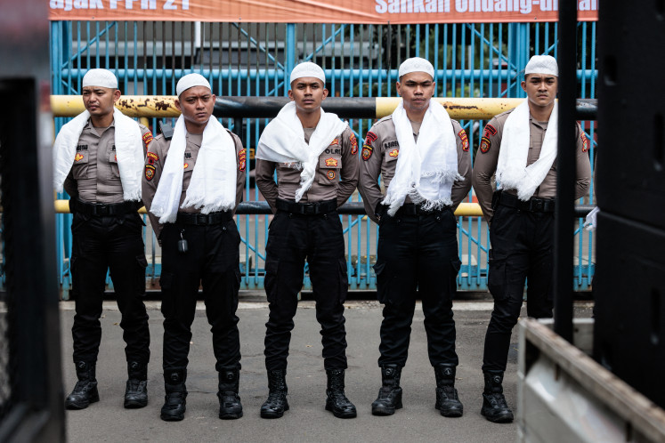 Police officers wearing white religious attire during the Muslim holy month of Ramadan stand guard during a labour union protest on March 4 in Jakarta. 