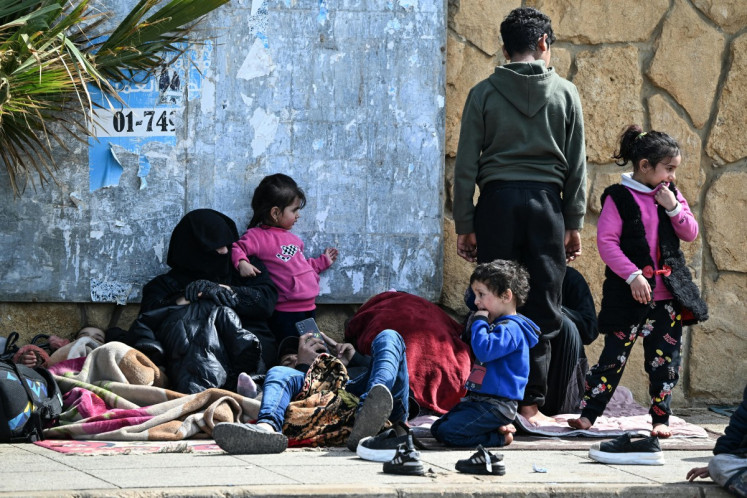Displaced residents who fled Israeli airstrikes in Beirut's southern suburbs sit along the corniche waterfront in the Lebanese capital on March 6, 2026.  