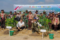 Green movement: Forestry Minister Raja Juli Antoni (crouching right) and Deputy Environment Minister Diaz Hendropriyono (crouching left) pose for a photo on March 3, 2026, after planting a tree to mark the start of land restoration in Tesso Nilo National Park.