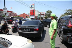 An employee directs motorists lining up to buy fuel at a gas station in Banda Aceh on March 5, 2026.