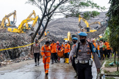 Rescuers evacuate a victim following a landslide at Bantargebang landfill in Bekasi, West Java, on March 9, 2026. 