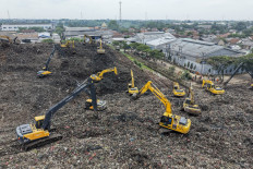 This aerial picture shows a rescue team using heavy machinery to search for people following a landslide at Bantargebang landfill in Bekasi, West Java, on March 9, 2026. A landslide on Indonesia's biggest landfill buried trucks and food stalls, killing four people, rescuers said on March 9 as they searched for at least five more reported missing.