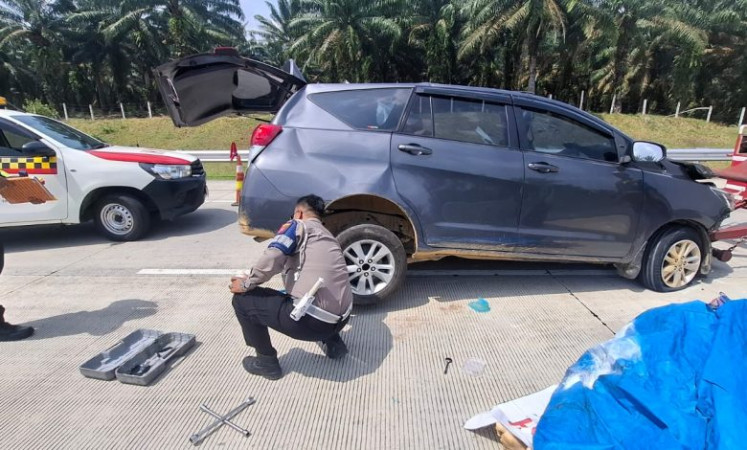 A Batubara Traffic Police Unit officer inspects a vehicle on March 6, 2026, at Km. 134 of the Kisaran-Indrapura toll road heading to Indrapura in Batubara regency, North Sumatra, following an accident that killed four passengers and seriously injured three others.
