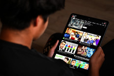 A 13-year-old boy poses at his home as he looks at social media on his tablet in Sydney on December 8, 2025. Australia will ban young teenagers from social media on December 10, 2025, launching a world-first crackdown designed to unglue children from addictive scrolling on the likes of Facebook, Instagram and TikTok.