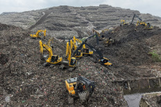 Desperate search: A rescue team uses heavy machinery to search for people on March 9  following a landslide at Bantargebang landfill in Bekasi, West Java. A landslide at the country&rsquo;s biggest landfill buried trucks and food stalls, killing four people, rescuers said on March 9 as they searched for at least five more reported missing.