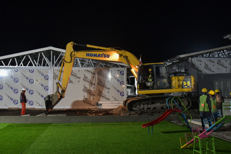 Workers operate heavy machinery on Feb. 21, 2026, to establish a 19-block, 228-room temporary housing complex in Tunyang village, Bener Meriah, Aceh.  